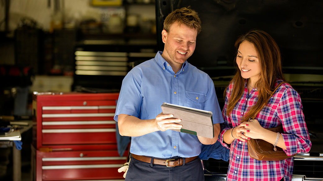 mechanic and costumer watching a tablet